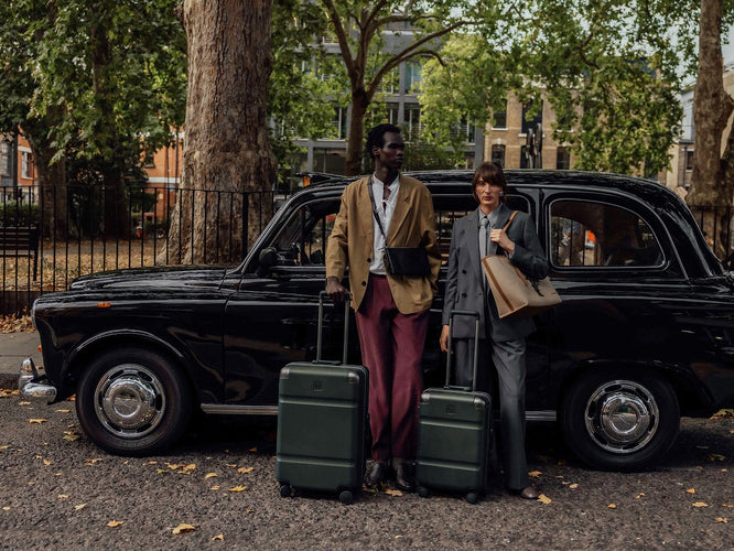 a man and woman standing next to a car with luggage