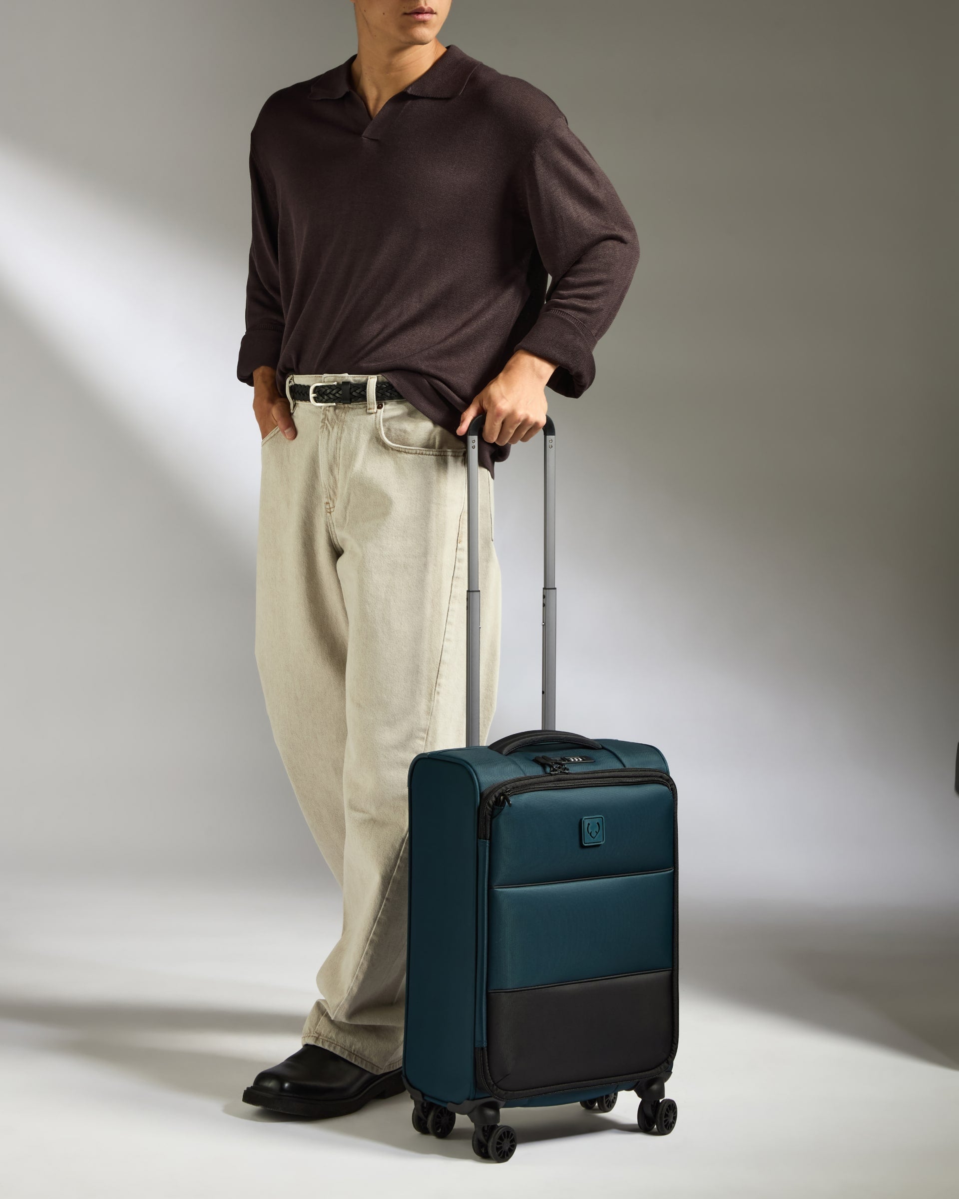 a man standing with his hand on his handle and a suitcase