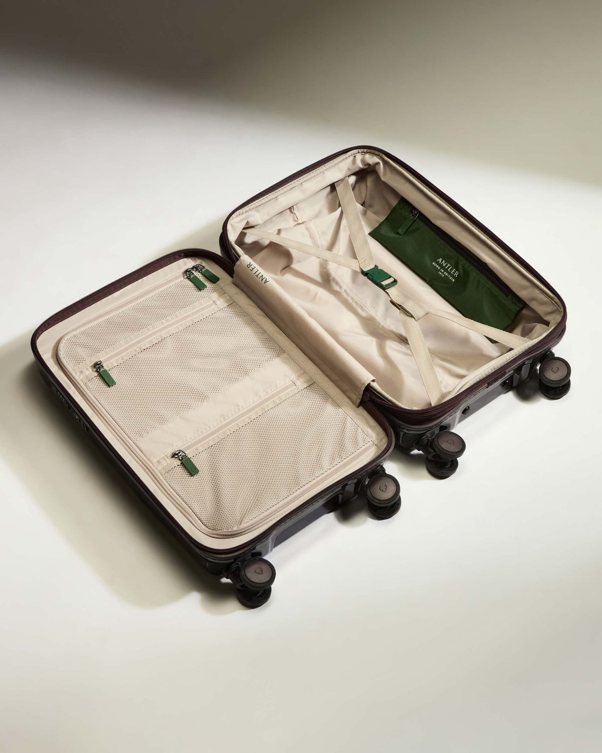 a suitcase with wheels and a green bag