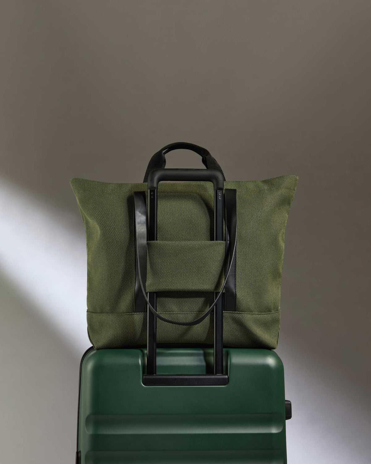 a green bag on top of a green suitcase