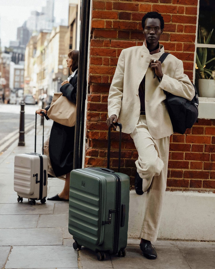a man leaning against a wall with luggage