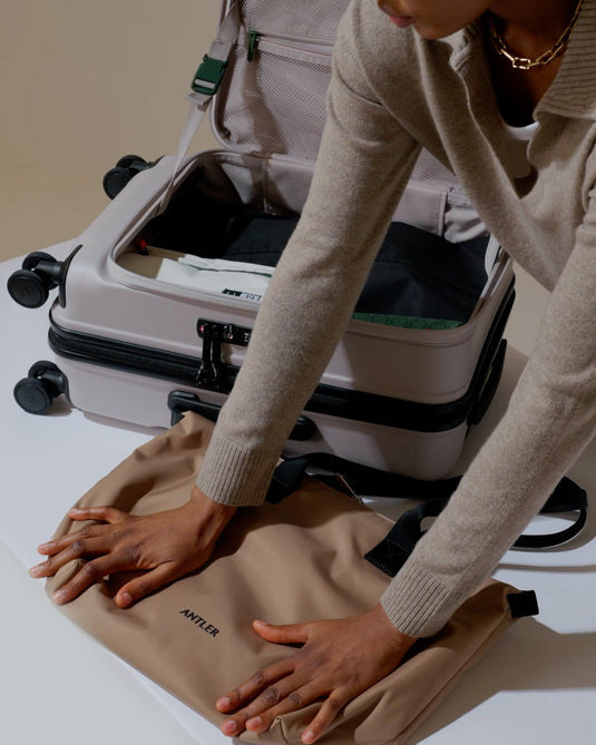 a person packing a suitcase